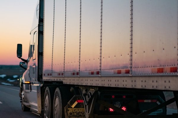 A loaded trailer on the highway at dusk